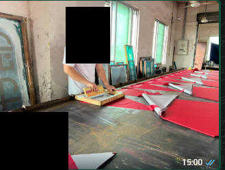 红色雨伞伞片印刷现场，人员面部和局部图案已遮盖